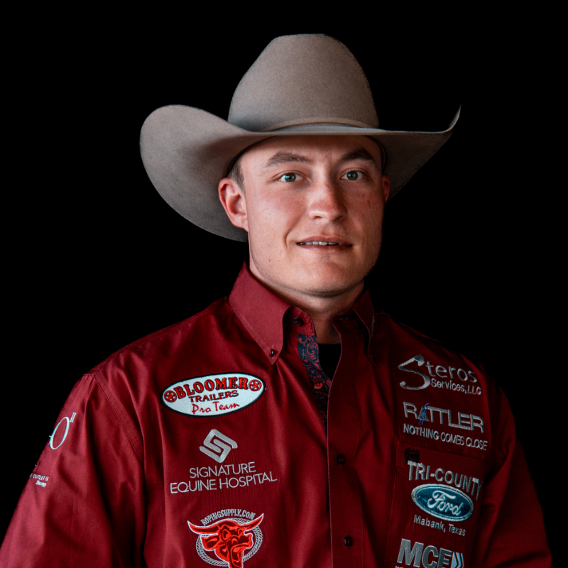 Bull rider Cooper James's headshot is shown. He's wearing a white button up shirt and a tan cowboy hat.